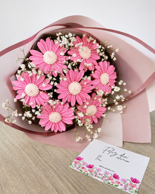 Bouquet of pink flowers with a card on a wooden surface