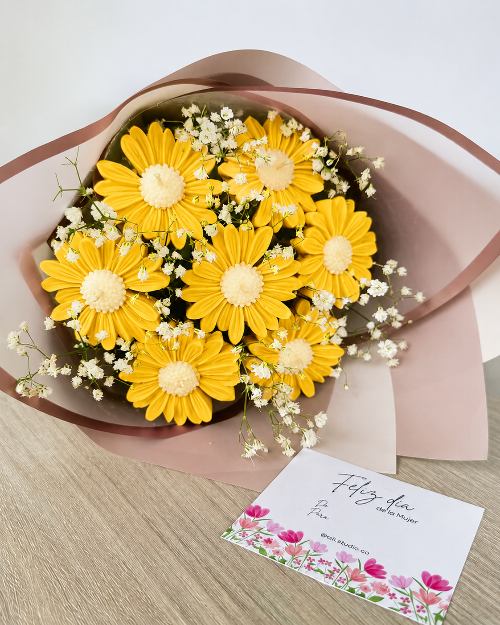 Bouquet of yellow flowers with a card on a wooden surface